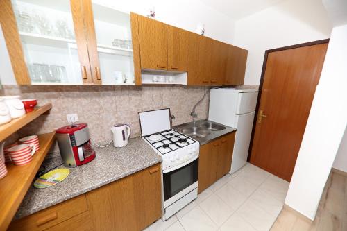 a kitchen with wooden cabinets and a stove top oven at Apartments Anka in Rtina