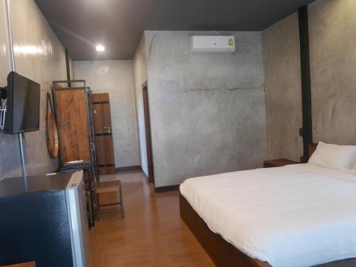 a bedroom with a bed and a tv in a room at SP Home BangSaen in Bangsaen