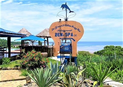 a sign at a resort with the ocean in the background at Le Grand Bleu in Andilana