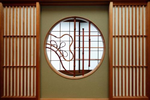 a round window on a wall with a tree in it at Ryokan ASAKUSA-chaka- by Tranova in Tokyo