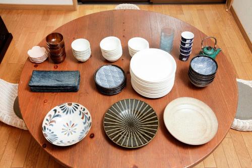a wooden table with plates and bowls on it at Ryokan ASAKUSA-chaka- by Tranova in Tokyo