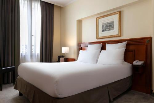En eller flere senge i et værelse på Hotel Saint Cyr Etoile