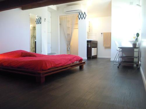 um quarto com uma cama vermelha e uma secretária em CONFORTABLE em Pérols