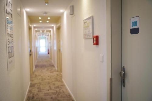 a hallway in a hospital with a long corridor at Kyriad Hôtel La Fleche in La Flèche