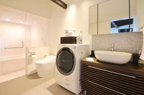 a bathroom with a washing machine and a sink at Kanazawa Bettei Yuan in Kanazawa