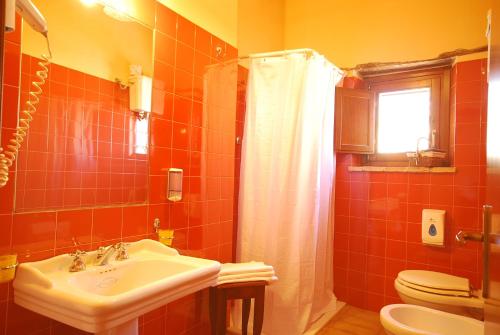 a bathroom with a sink and a toilet at Country House La Lungavita in San Terenziano