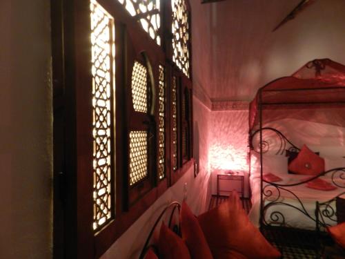 a room with a window and a bed with red pillows at Riad Jamaï in Fès