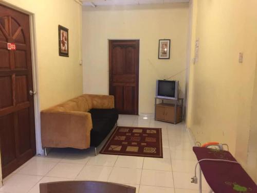 ein Wohnzimmer mit einem Sofa und einem TV in der Unterkunft trisya homestay in Kuala Terengganu