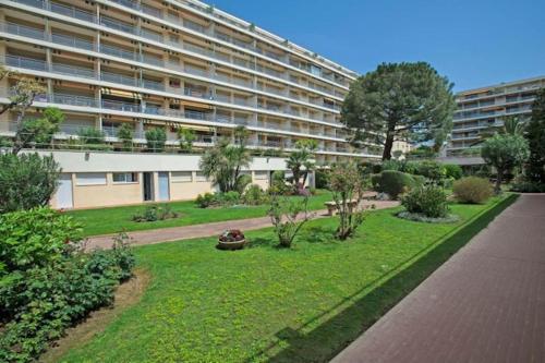 un gran edificio con un jardín delante de él en #PACAGROOM# Studio Alexandre III en Cannes