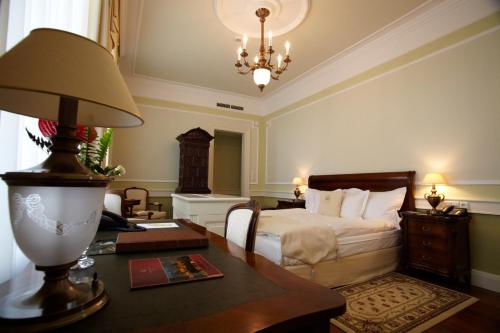1 dormitorio con 1 cama y 1 mesa con lámpara en Hertelendy Kastély Exclusive en Kutas