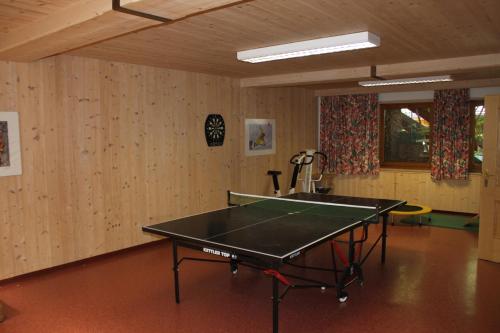 a ping pong table in a room with wooden walls at otto steiner appartements pension ellmau & wilder kaiser in Ellmau
