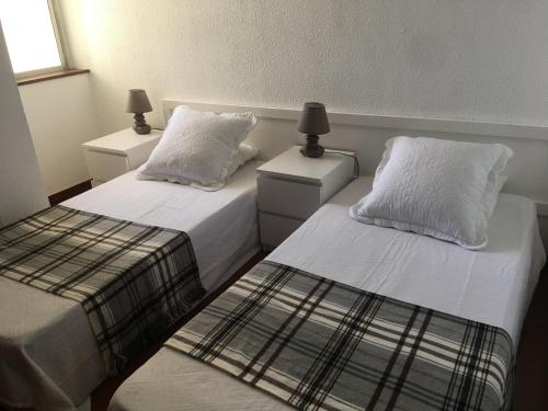 1 Schlafzimmer mit 2 Betten mit weißer Bettwäsche und Kissen in der Unterkunft Ma vue mer en Algarve in Portimão