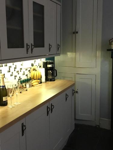 a kitchen with white cabinets and a counter top at 2 Emma Place in Bodmin