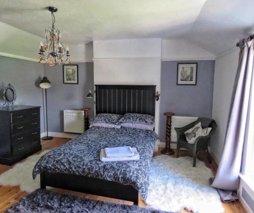 a bedroom with a large bed and a chair at 2 Emma Place in Bodmin