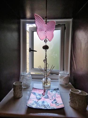 a table with a window with a pink lamp on it at 2 Emma Place in Bodmin