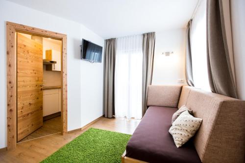Una sala de estar con un sofá y un espejo. en Reden Hof, en Selva dei Molini