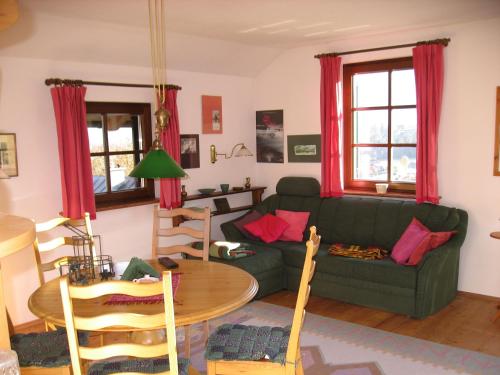 a living room with a green couch and a table at Villa Laske in Altaussee