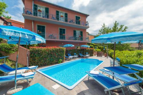 una piscina con sedie e ombrelloni accanto a un edificio di Hotel Ca' De Berna a Balestrino