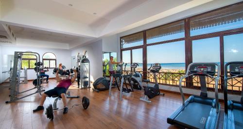 a man exercising in a gym with a view of the ocean at Stella Beach Resort & Spa, Makadi Bay in Hurghada