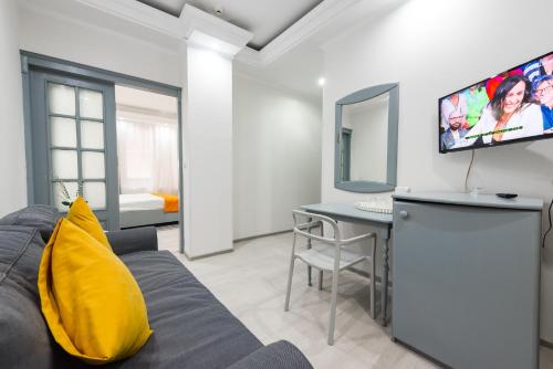 a living room with a couch and a table and a tv at Relax Comfort Suites Hotel in Bucharest