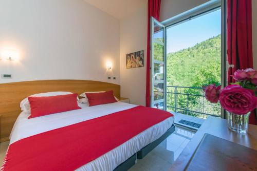 una camera con un grande letto e una grande finestra di Hotel Ca' De Berna a Balestrino
