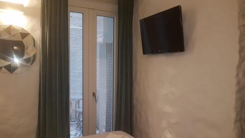 Cette chambre dispose d'une télévision murale et d'une fenêtre. dans l'établissement Room Del Giglio, à Bari