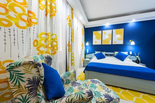 فندق ريلاكس كمفورت سويتس في بوخارست: غرفة نوم زرقاء مع سرير وأريكة