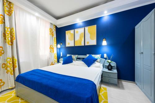 a blue bedroom with a bed and blue walls at Relax Comfort Suites Hotel in Bucharest