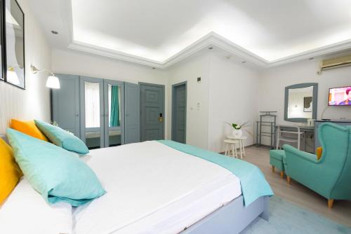 a bedroom with a white bed and a blue chair at Relax Comfort Suites Hotel in Bucharest