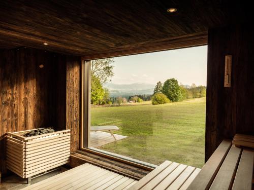 a large window in a room with a view of a field at Alpenloge Design Hotel in Scheidegg