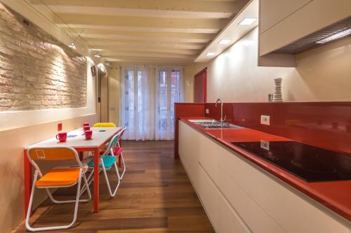 Apartments Moon or Dama في البندقية: مطبخ مع طاولة وكراسي ومغسلة
