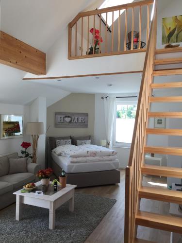 a living room with a bed and a staircase at Villa "Auszeit" in Hohen Neuendorf