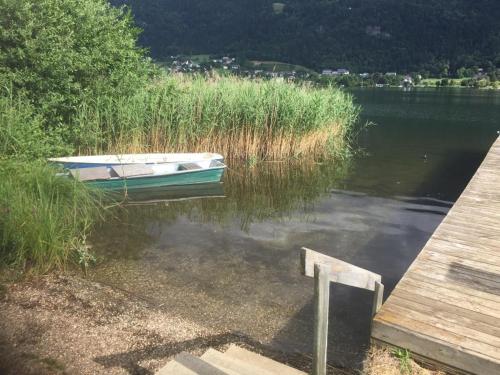 a boat sitting on the water next to a dock at Seechalet in Altossiach