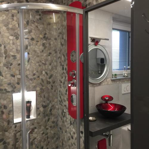 a bathroom with a shower with a red sink at LA CASA DEI NONNI con SPA privata su richiesta in Pont Canavese
