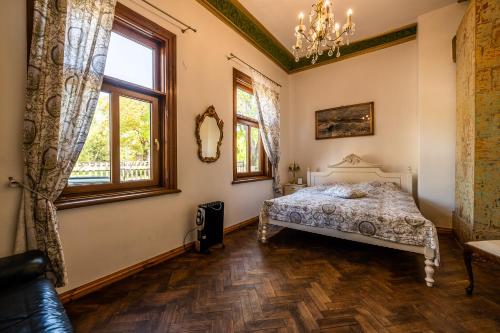 a bedroom with a bed and a chandelier at Villa Apartments by the sea in Liepāja