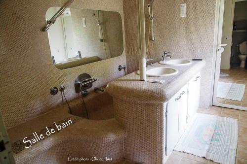 a bathroom with two sinks and a mirror at La tricherie - maison d'hotes in Crastes