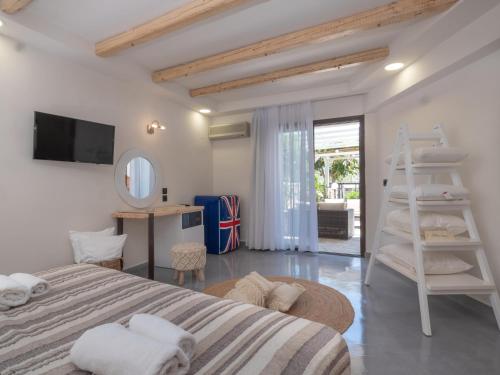 a white bedroom with a bed and a ladder at Eva Mare Hotel & Suites - Adults only in Agia Pelagia