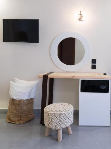 a dressing table with a mirror and a stool at Eva Mare Hotel & Suites - Adults only in Agia Pelagia