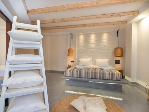 a bedroom with a bunk bed and a ladder at Eva Mare Hotel & Suites - Adults only in Agia Pelagia