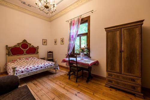 a bedroom with a bed and a desk and a window at Veranda Suite in Liepāja