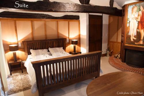 a bedroom with a bed and a table and a television at La tricherie - maison d'hotes in Crastes