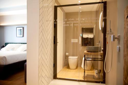 a bathroom with a shower and a bedroom with a bed at Meg Lifestyle Hotel in Riccione