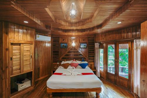 1 dormitorio con 1 cama en una habitación de madera en Phu Pha Aonang Resort & Spa, en Ao Nang Beach