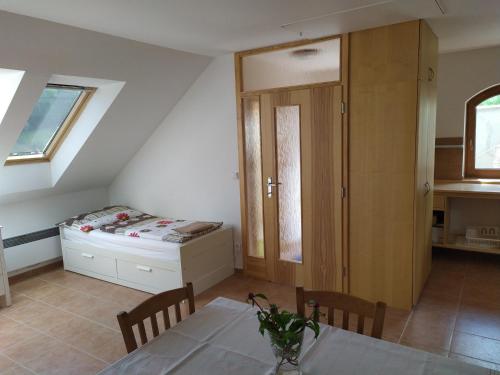 a dining room with a table and a bed in a room at Apartment Koprivovi in Němčičky
