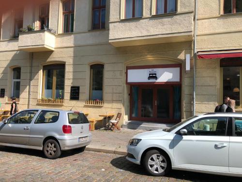 two cars parked in front of a building at Pension Kaffeefreunde in Berlin