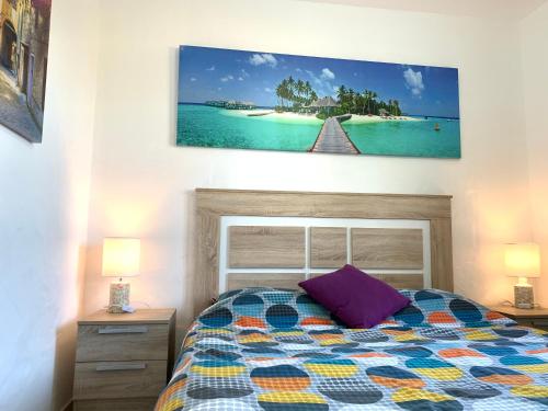 カレタ・デ・フステにあるNew Apartment Sun beachのベッドルーム1室(ベッド1台付)が備わります。壁には絵画が飾られています。