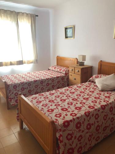 um quarto com 2 camas e uma cómoda em Apartamento 2ª planta Ca'n Miquel em Cala Galdana