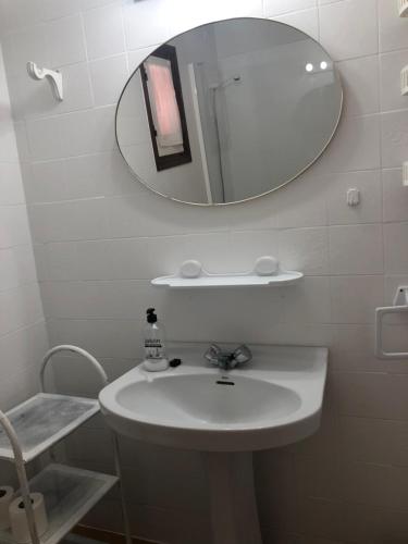 y baño con lavabo blanco y espejo. en Apartamento 2ª planta Ca'n Miquel, en Cala Galdana