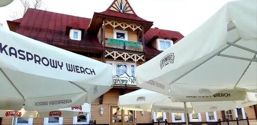 a group of white umbrellas in front of a building at Resort Kasprowy Wierch in Zakopane