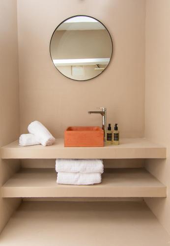 a bathroom with a mirror and towels on a shelf at Cosmo Luxe in Mikonos